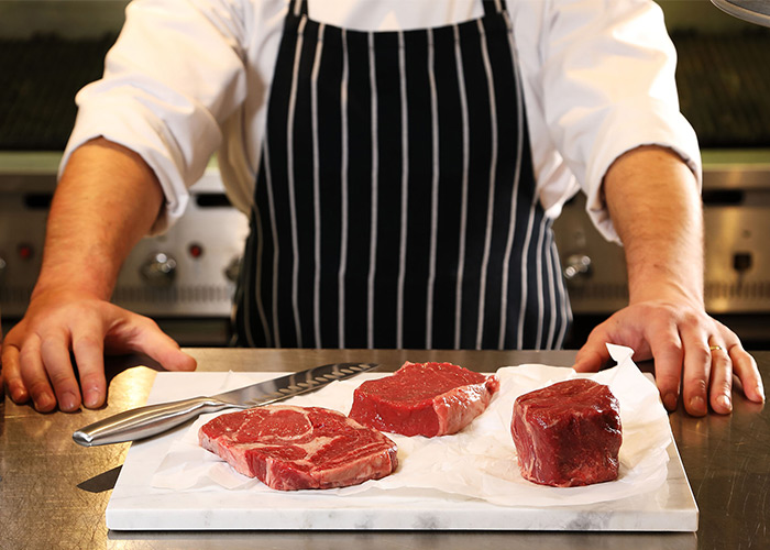 Master butcher hand-cutting prime-aged beef cuts at Miller & Carter