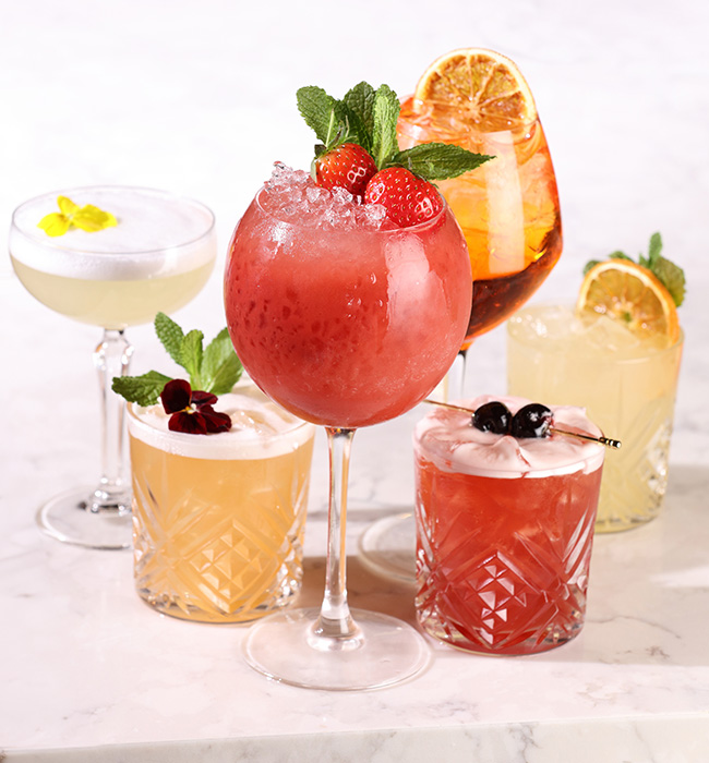 Selection of Miller & Carter cocktails showcasing vibrant garnishes, promoting cocktail offers and seasonal drinks.
